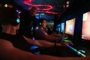 People playing video games in a dimly lit room.