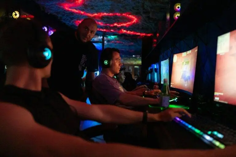 People playing video games in a dimly lit room.