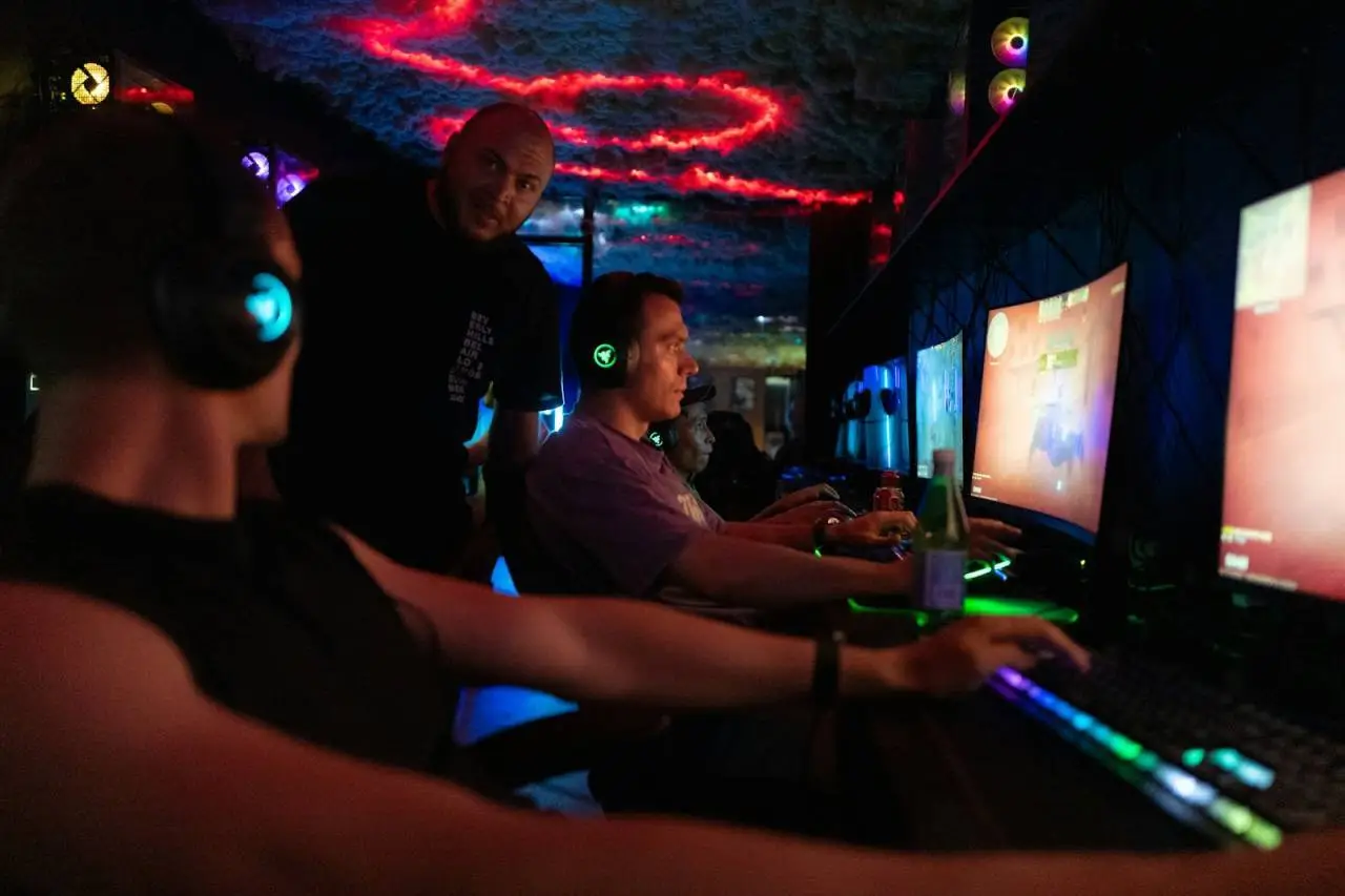 People playing video games in a dimly lit room.